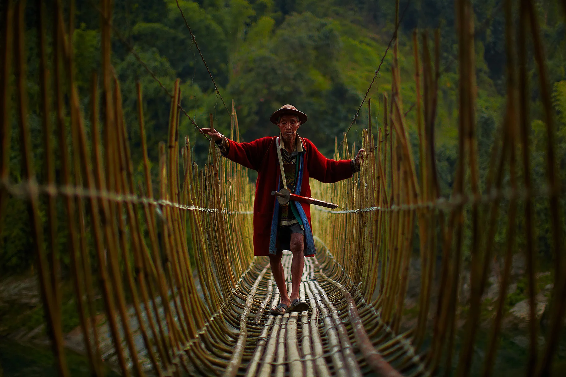 Homme franchissant une passerelle tressée photographié par Andrew Newey