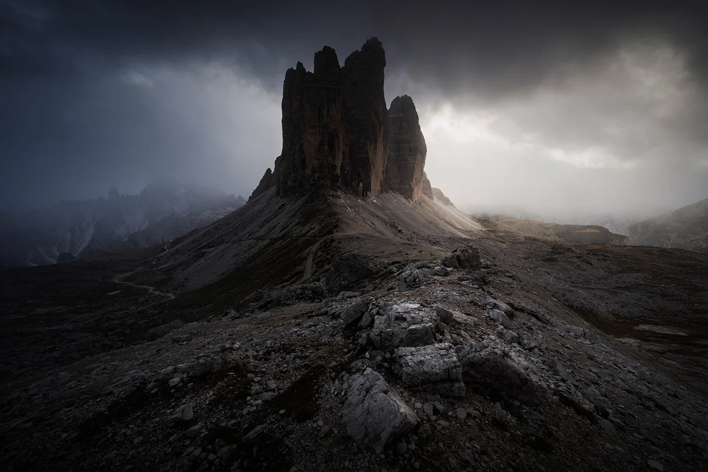 Tours rocheuses sombres dressées dans un paysage minéral et brumeux