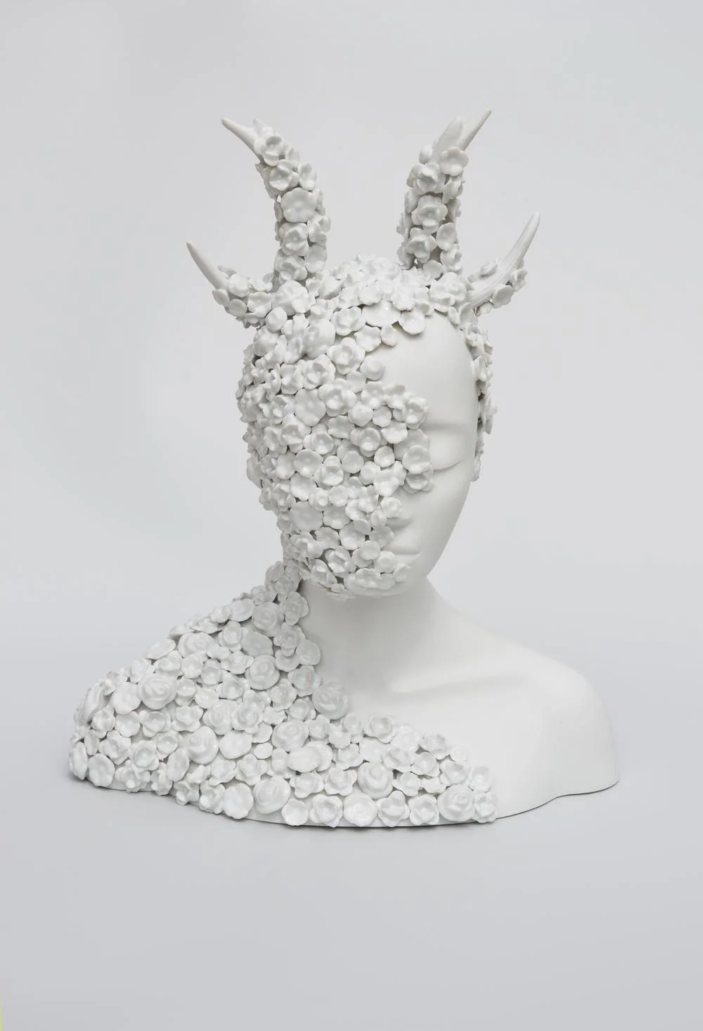 Créature féminine à cornes couverte de petites fleurs blanches en porcelaine par Juliette Clovis
