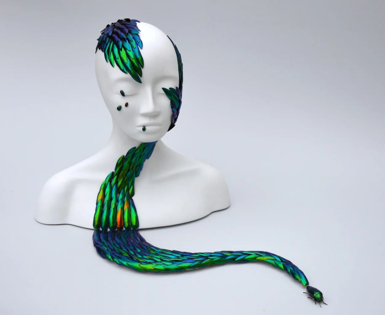 Buste blanc prolongé par une forme serpentine composée d’ailes d’insectes irisées par Juliette Clovis