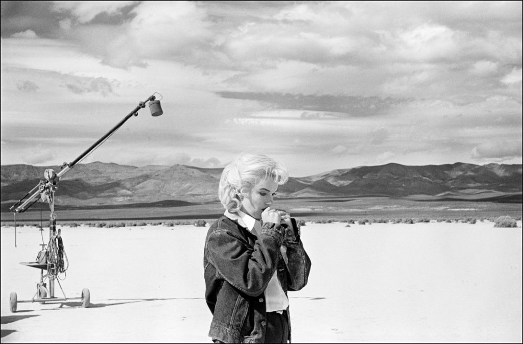 ETATS-UNIS. Nevada. L'actrice américaine Marilyn MONROE dans le désert du Nevada revoit ses répliques pour une scène difficile qu'elle s'apprête à jouer avec Clarke GABLE dans le film "The Misfits" de John HUSTON. 1960. EVE ARNOLD