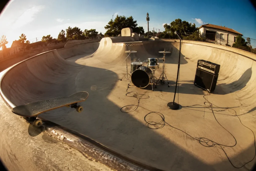 Skatepark avec batterie, amplificateur et skateboard, évocation de la culture pop-punk des années 2000